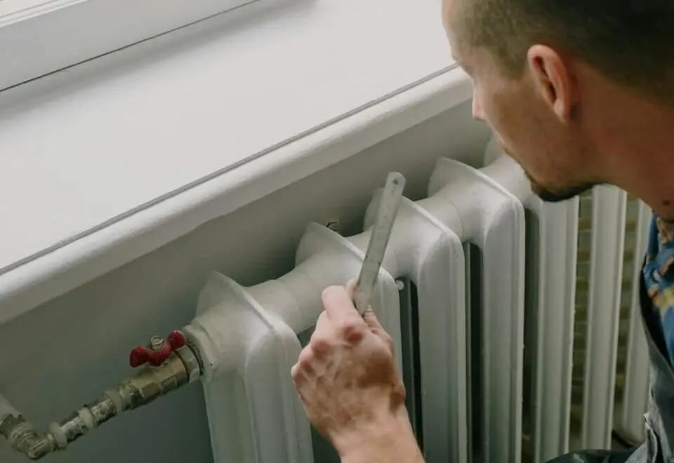 Expert is onderhoud op een verwarming aan het uitvoeren