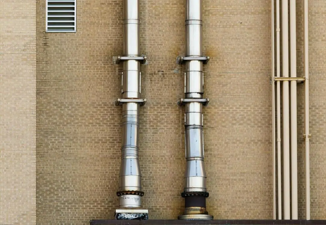 Ventilatiepijpen die langs een huis lopen