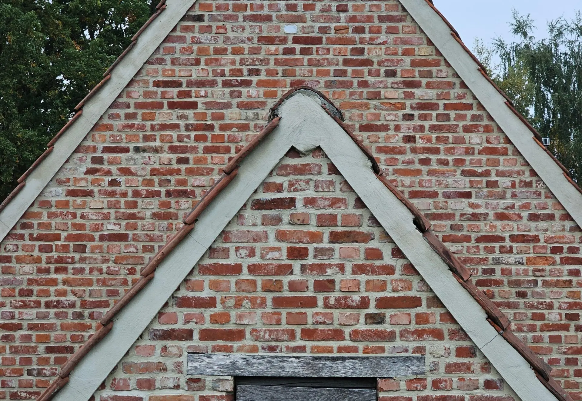 Huis van voren met bakstenen en witte dakgevels goed zichtbaar