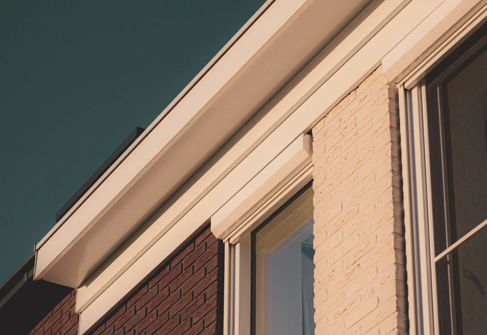 Rijtjeswoning van de zijkant met witte dakgevel en bakstenen met ramen